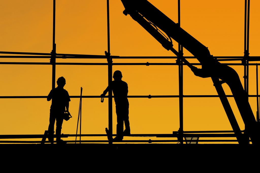2 workers working on the construction in the sunset