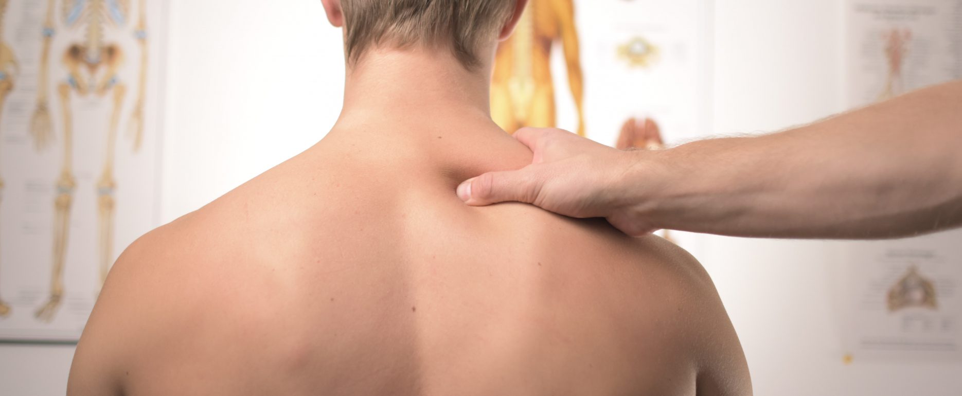 Man on medical examination with doctor checking his back