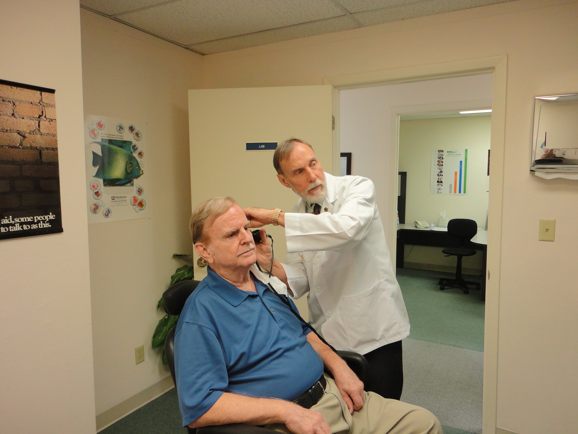 What to expect at the audiologist? Man going throug a hearing check with doctor examining him