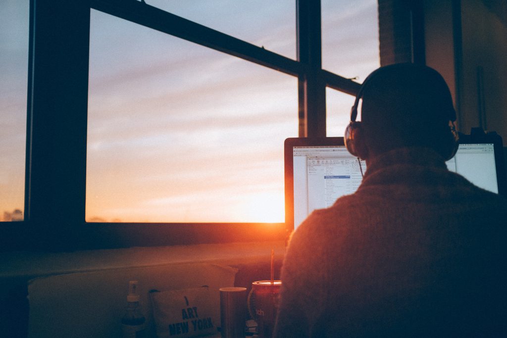 Man sitting in the office with heaphones on working