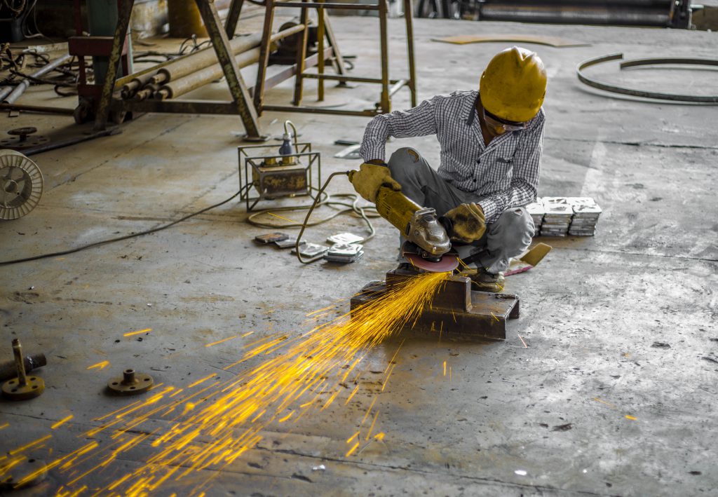 Industrial worker working with the metal, dealing with ear ringing or Tinnitus at work