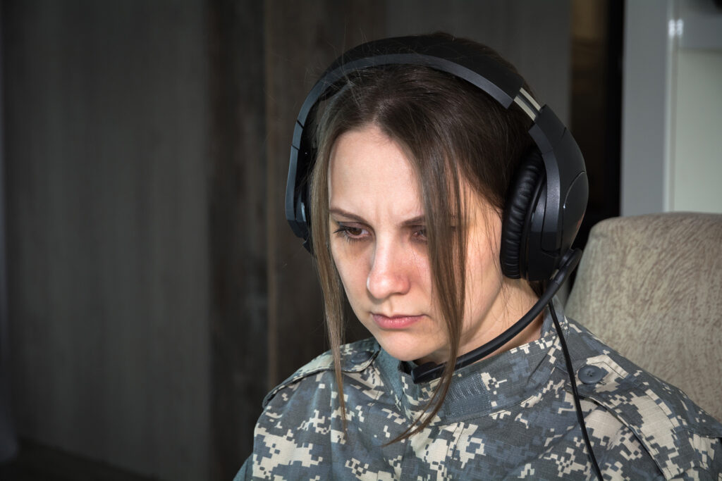 What is Woman with headset looking at the screen.Acoustic Shock Syndrome?